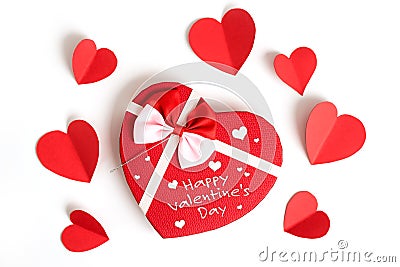 Happy valentines day, heart shape gift box with ribbon and small paper hearts with written note, on white background, top view Stock Photo