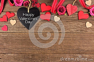 Happy Valentines Day heart shaped chalkboard tag with border against rustic wood Stock Photo