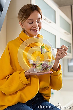 Happy vegetarian kindly looking at the bowl of salad and smiling Stock Photo