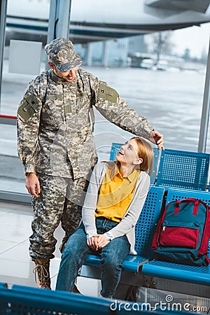 Happy veteran in military uniform looking at surprised girlfriend Stock Photo