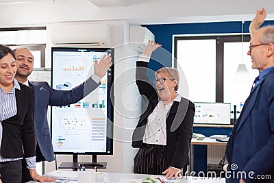 Happy victorious business people in start up company celebrating Stock Photo