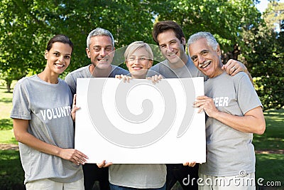 Happy volunteer family holding a blank Stock Photo