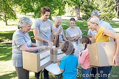 Happy volunteer family separating donations stuffs Stock Photo