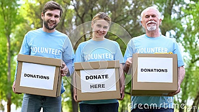 Happy volunteers holding donation cardboxes, humanitarian aid assistance project Stock Photo