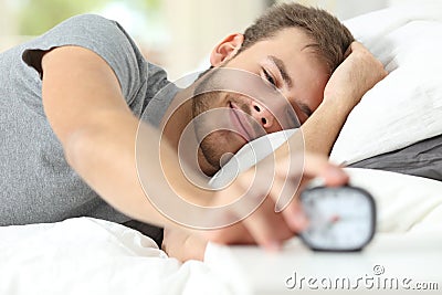 Happy wake up of a happy man stopping alarm clock Stock Photo