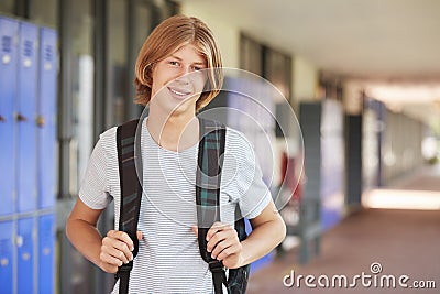 Happy white teenage boy smiling in high school corridor Stock Photo