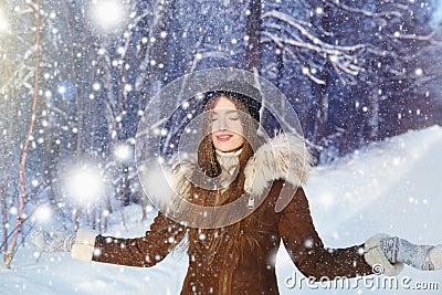 Happy winter fun woman playing throwing snow with arms up open in freedom enjoying the cold season Stock Photo