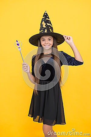 Happy witch teenage girl with magic wand wear costume of wizard on halloween party, halloween Stock Photo