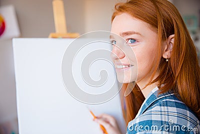 Happy woman artist making sketches on canvas in art class Stock Photo