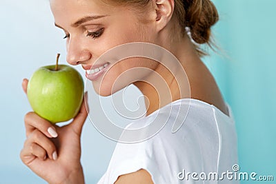 Happy Woman With Beautiful Smile, Healthy Teeth Holding Apple Stock Photo