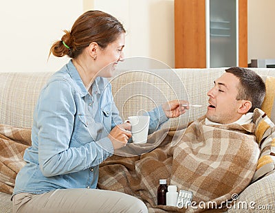 Happy woman caring for sick husband Stock Photo