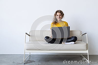 Happy woman chatting online on laptop. Smiling blonde woman messaging with friends on computer. Social media, communication and Stock Photo