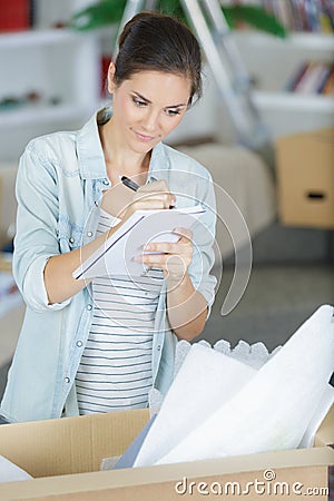 happy woman checking stuff in cardboard box Stock Photo