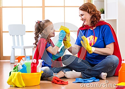 Happy woman with child cleaning room and having fun playing at home. Family housework conception. Stock Photo