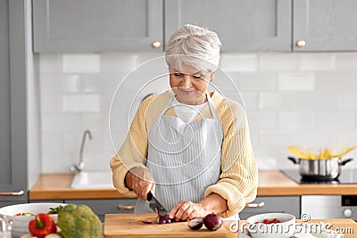 happy woman chopping red onion on kitchen Stock Photo