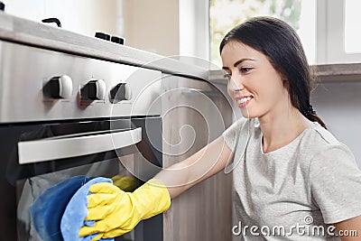 Happy woman cleaning oven Stock Photo