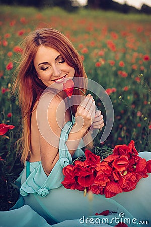 Happy woman with closed eyes holding bouquet of poppies Stock Photo