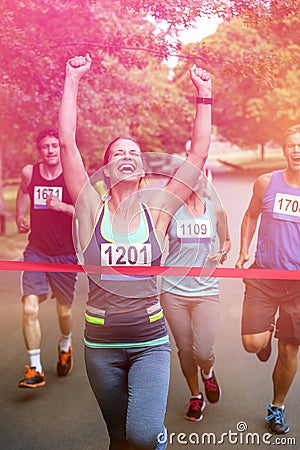 Happy woman crossing the finish line Stock Photo