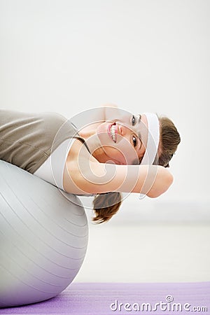 Happy woman doing abdominal crunch on fitness ball Stock Photo