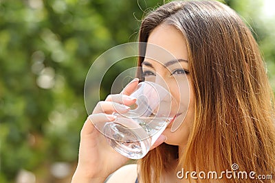 Happy woman drinking water from a glass outdoor Stock Photo