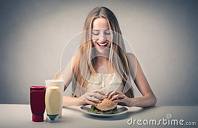 Happy woman eating a hamburger Stock Photo