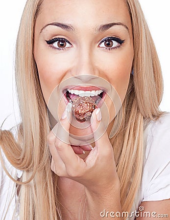 Happy woman eating praline Stock Photo