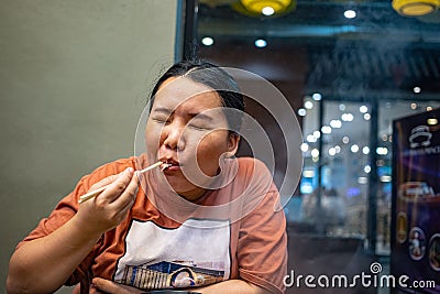 Happy woman enjoying eating in restaurant Stock Photo