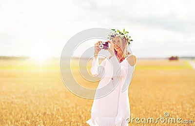 Happy woman with film camera in wreath of flowers Stock Photo