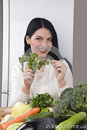 Happy woman with fresh parsley and vegetables Stock Photo