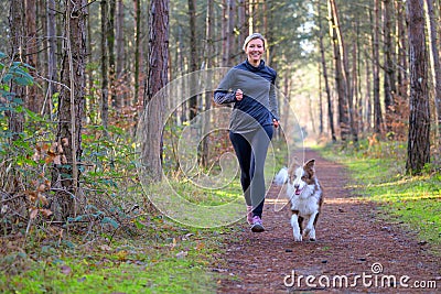 Happy woman full of vitality exercising her dog Stock Photo