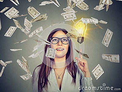 Happy woman in glasses has a successful idea under money rain Stock Photo