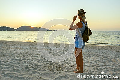 Happy Woman in Hat Enjoying Beautiful Sunset on the Beach. Travel in Asia concept. Stock Photo