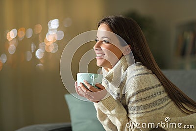 Happy woman holding coffee cup in winter at home Stock Photo