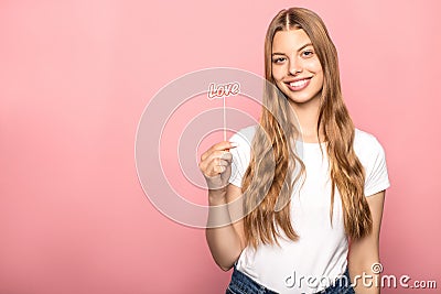 Woman holding love lettering on stick isolated on pink Stock Photo