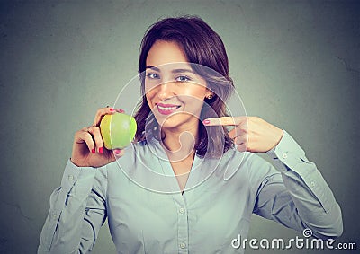 Happy young woman holding pointing at green apple Stock Photo