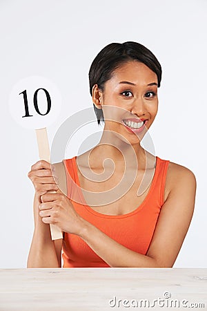 Happy Woman Holding Up Scorecard Giving Mark Out Of Ten Stock Photo