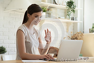 Young woman making video call on laptop and waving hand Stock Photo