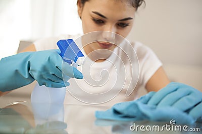 Happy woman house wife cleaning glass table in home Stock Photo