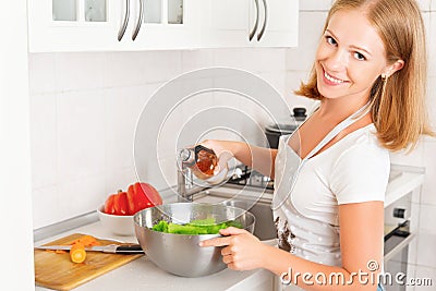 Happy woman housewife preparing salad in kitchen Stock Photo