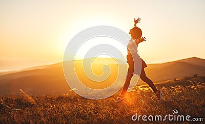 Happy woman jumping and enjoying life at sunset in mountains Stock Photo