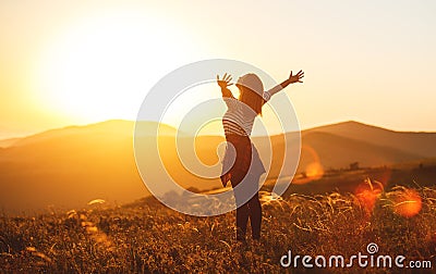 Happy woman jumping and enjoying life at sunset in mountains Stock Photo