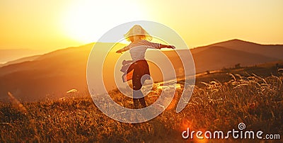 Happy woman jumping and enjoying life at sunset in mountains Stock Photo