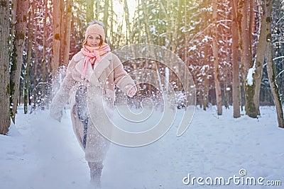 A happy woman kicks the snow, a winter forest with frozen trees Stock Photo