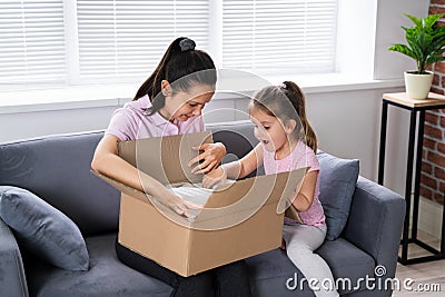 Happy Woman And Kid Opening Received Package Stock Photo