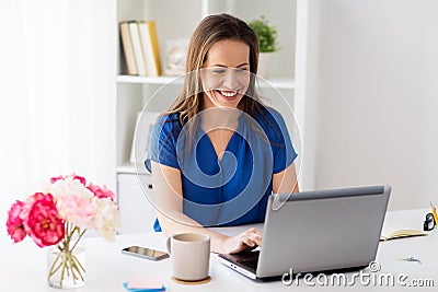 Happy woman with laptop working at home or office Stock Photo