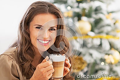 Happy woman with latte macchiato in front of christmas tree Stock Photo