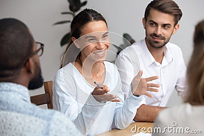 Happy woman leader coach mentor talking to employees at meeting Stock Photo