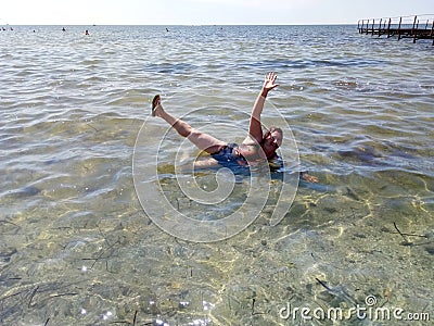 Happy woman lies in the sea Stock Photo