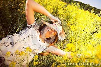 Happy woman lying among yellow wildflowers Stock Photo