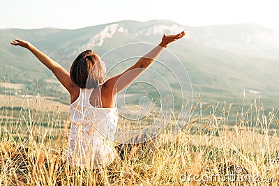 Happy woman meets sunrise in mountain Stock Photo